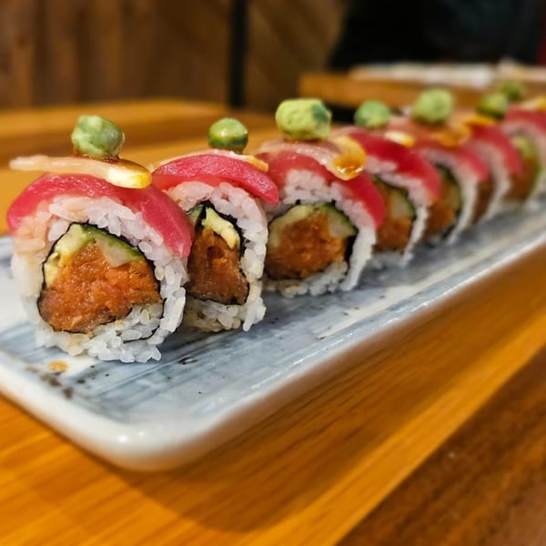 A row of Toro Sushi Poke House sushi rolls with tuna, avocado, and spicy filling.