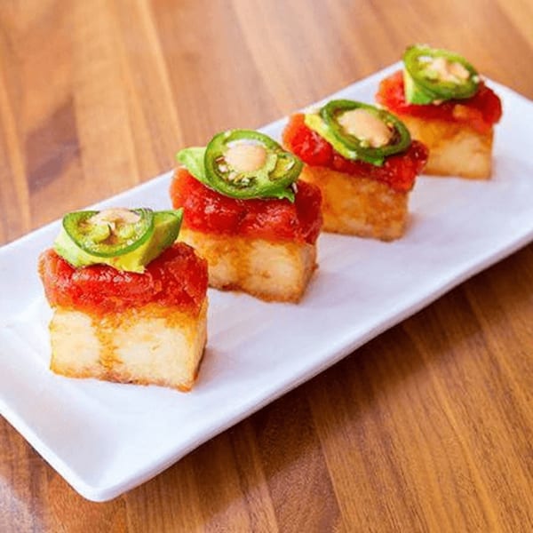 Four pieces of Toro Sushi Poke House's crispy rice with spicy tuna, avocado, and jalapeño.